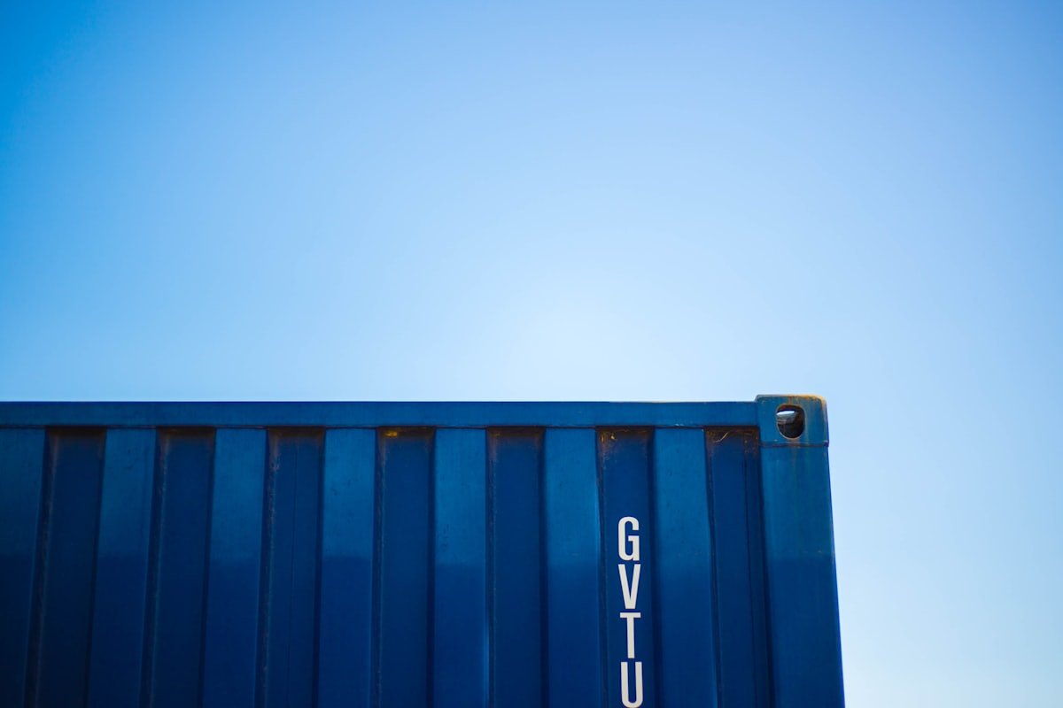 A blue shipping container against a clear sky