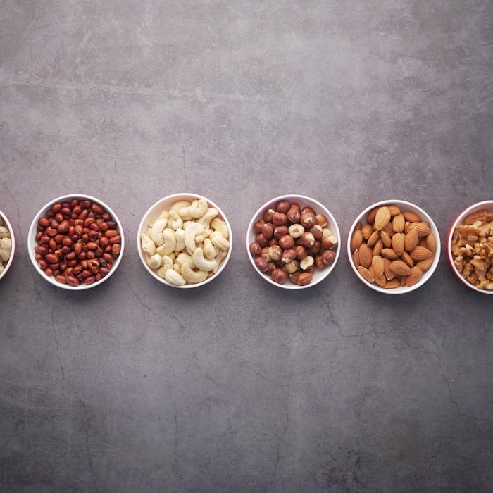 Bowls of assorted nuts arranged in a row