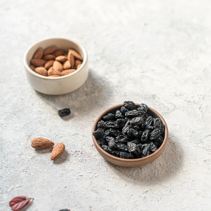 Black raisins and almonds in small bowls