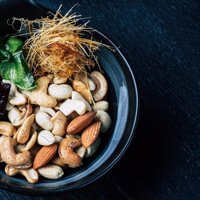Cashew kernels and almonds in a dark bowl