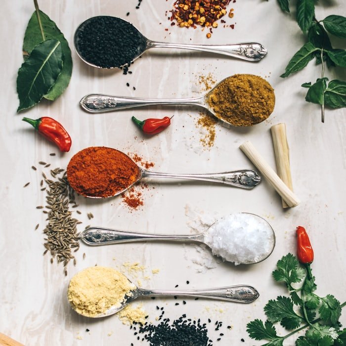 Silver spoons holding sample spices for grading